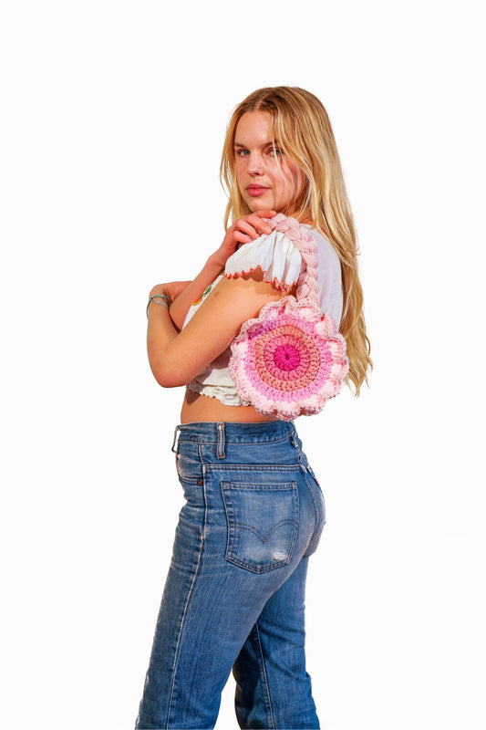 Model wearing flower shaped pink ombré crochet bag on her shoulder.