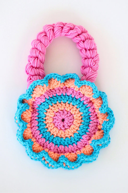 Flower shaped pink, orange, and blue crochet shoulder bag handmade with acrylic yarn.