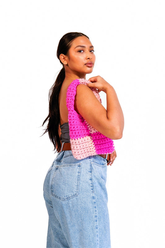 Model wearing hot pink and blush checkered crochet bag on her shoulder.