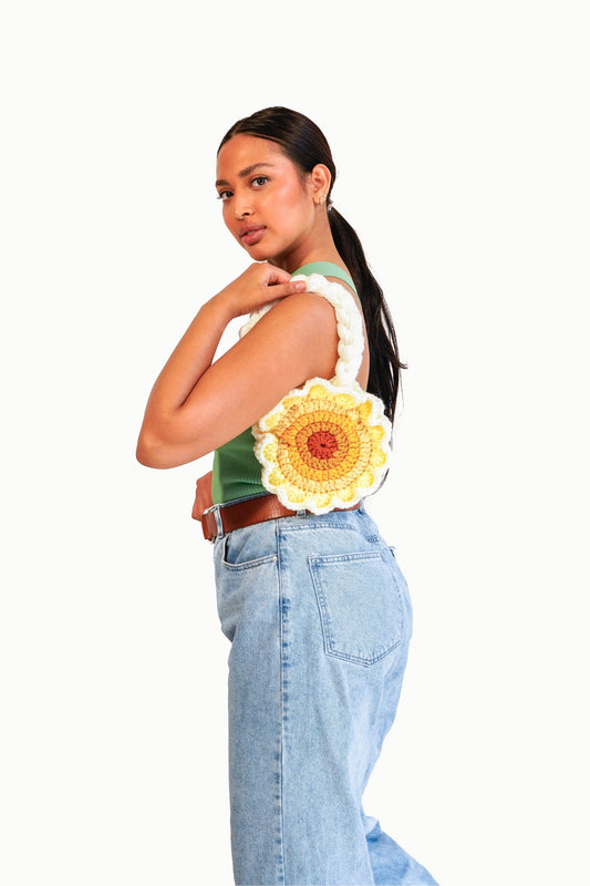 Model wearing flower shaped yellow ombré crochet bag on her shoulder.