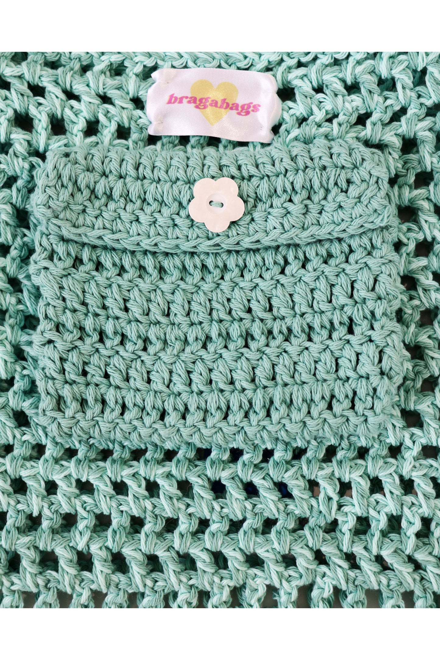 Close up of Caribe color way inside crochet pocket with flower button.