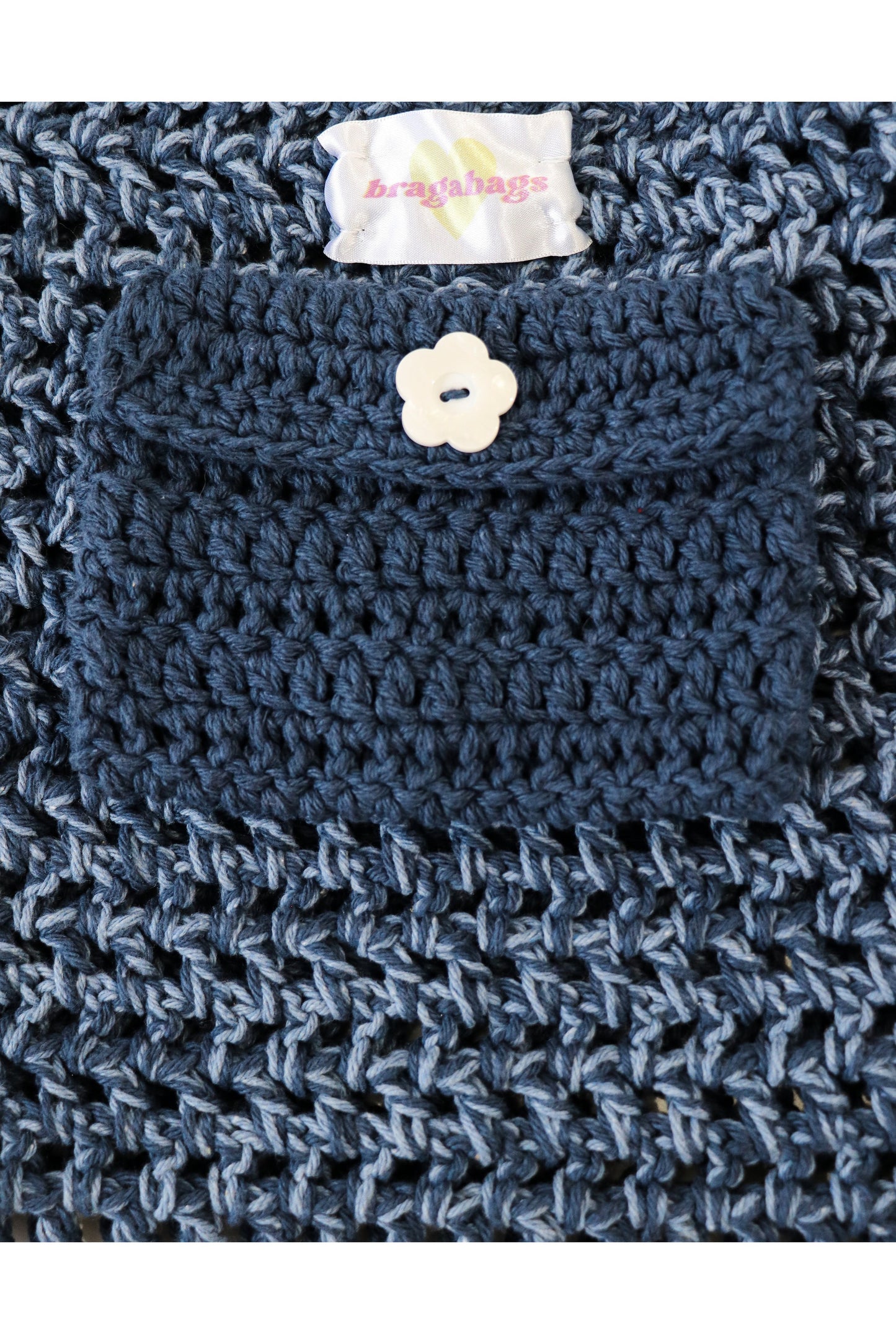 Close up of Denim color way inside crochet pocket with flower button.