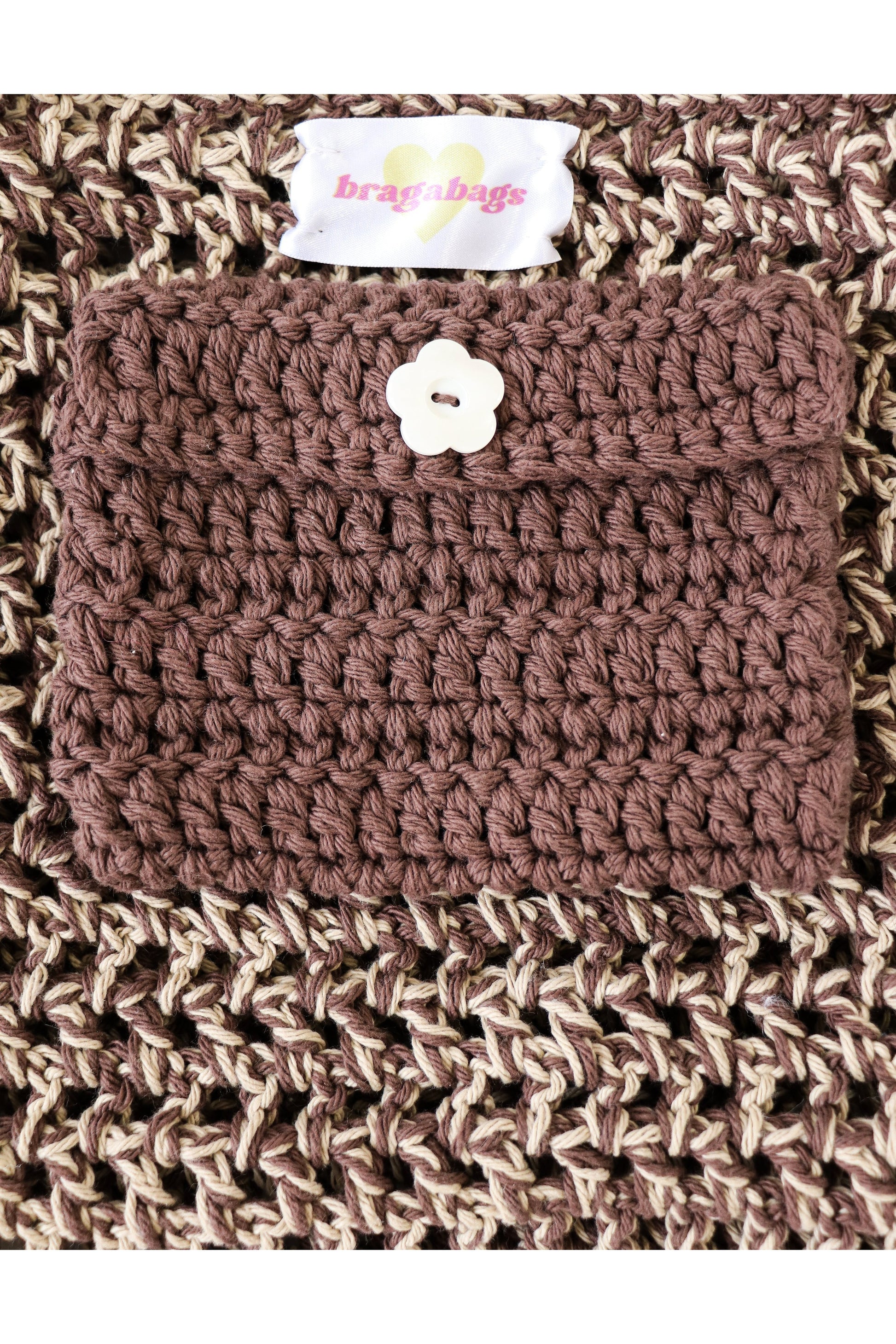 Close up of Whiskey color way inside crochet pocket with flower button.